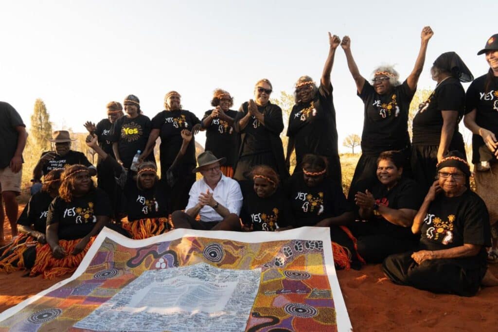 Anthony Albanese sits with Indigenous women at Uluru.