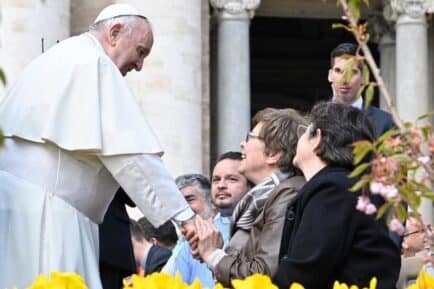 Pope Francis shaking the hand of a woman