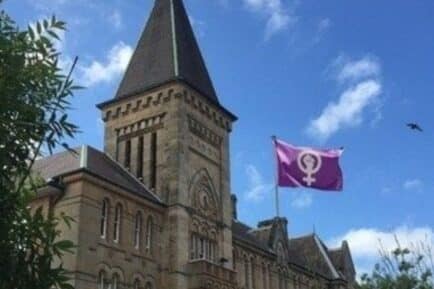 Old school building waving women's rights flag