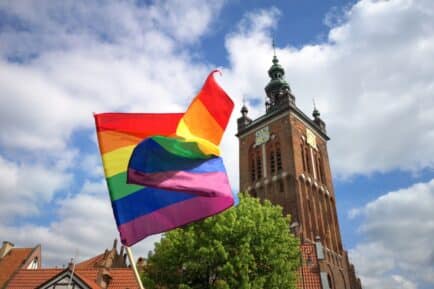 LGBTQIA+ flag flying in front of religious building