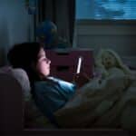girl lying in bed scrolling on smart phone