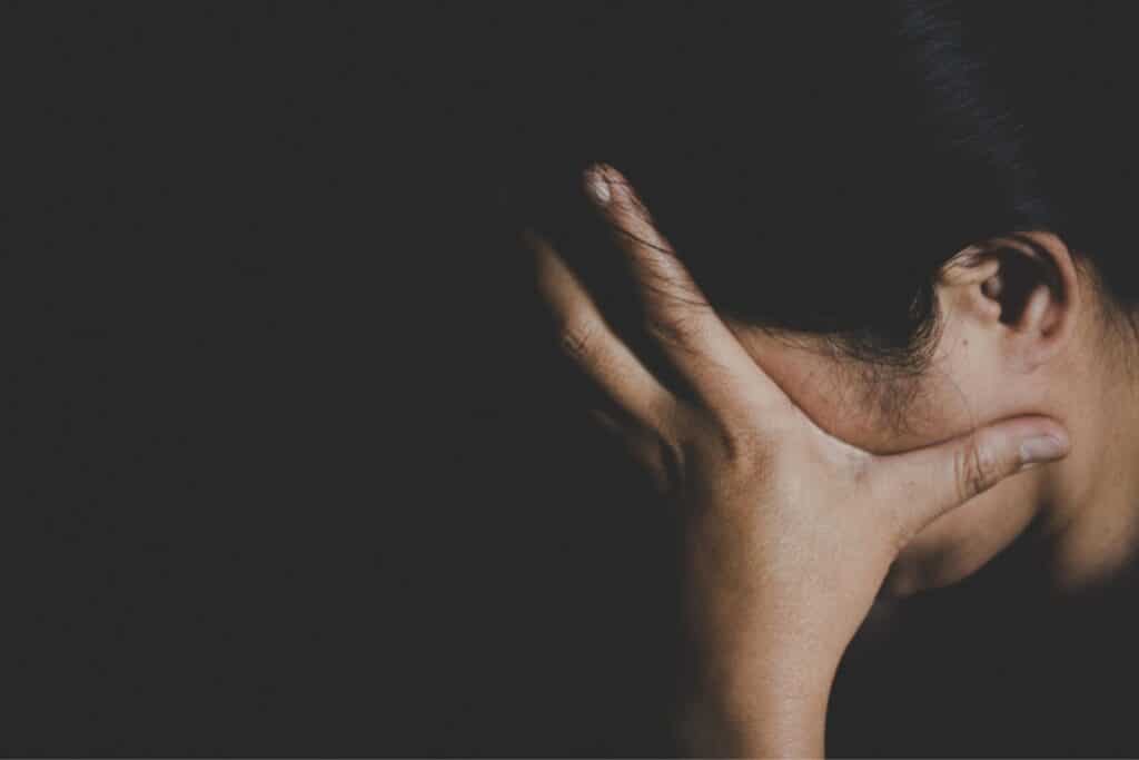 Woman holding head in hands